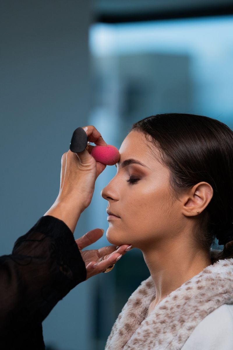 Cassandra Cassou aplicando esponja en el rostro de una modelo